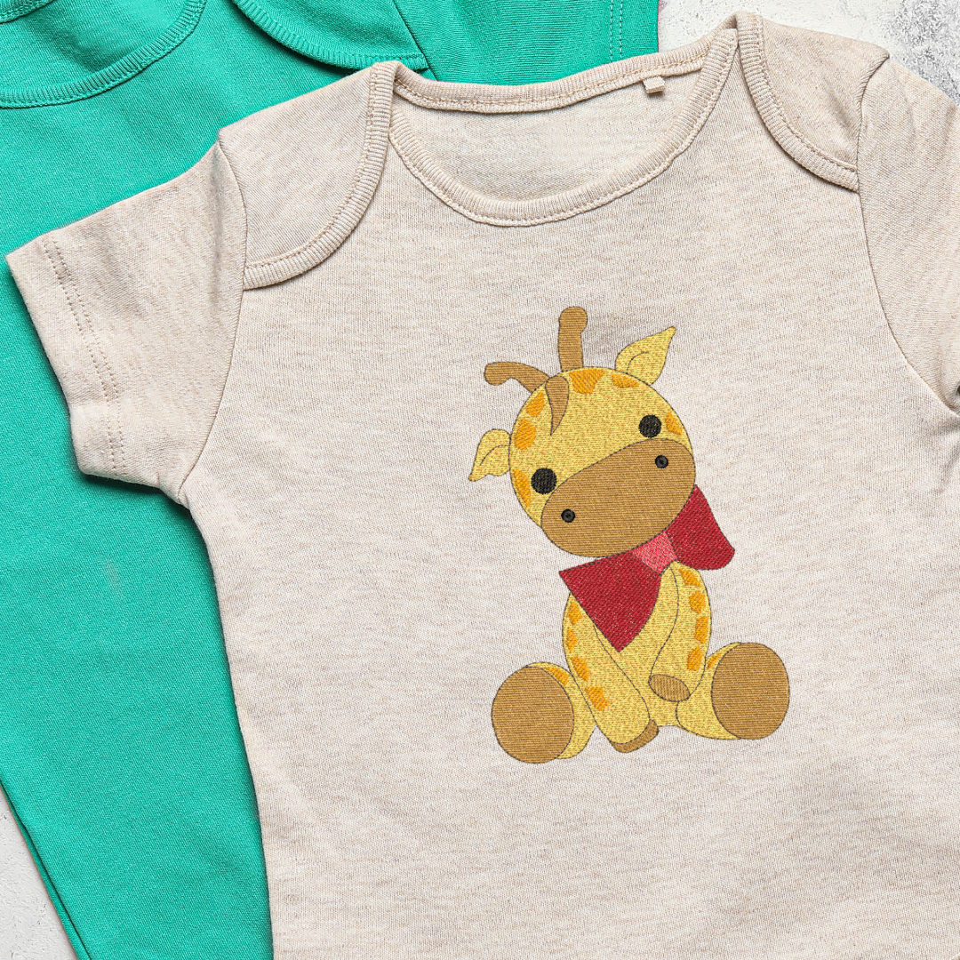 This is an image of a baby Giraffe with red bow machine embroidery design. This baby giraffe machine embroidery pattern can be embroidered on baby clothes and gifts for Baby Showers and Christmas.