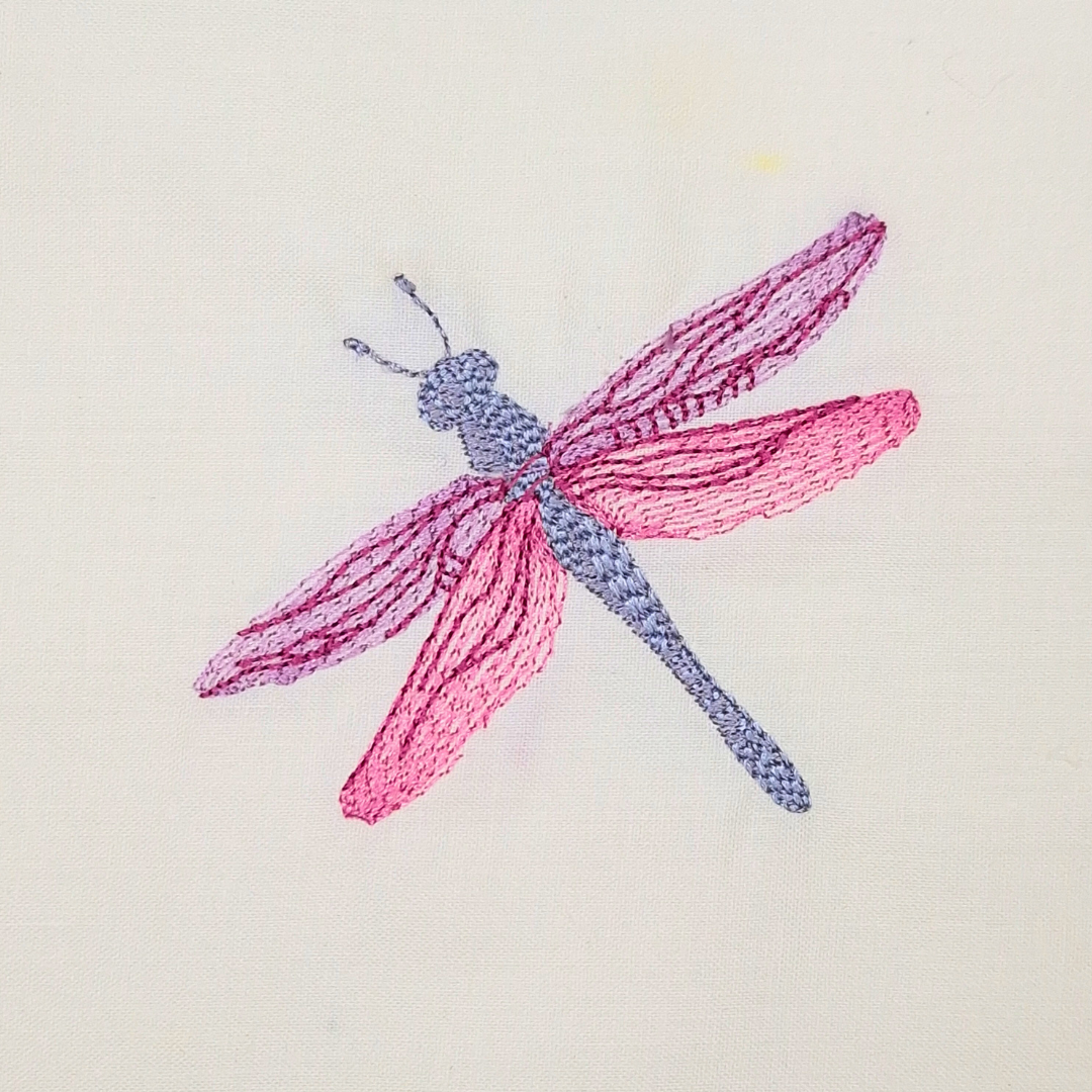 This is an image of a pink and purple dragonfly machine embroidery design. This dragonfly machine embroidery pattern is easy to make and is ideal for any project that needs a little sprucing up. Also add this dragonfly to brand-new creations like tote bags, tablecloths, denim pockets, and more.