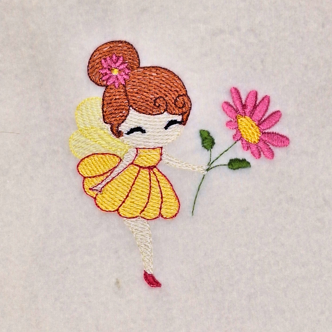 This is an image of a machine embroidery design featuring a red haired fairy in a yellow dress with raspberry pink detail. This fairy machine embroidery design is perfect for embroidery on girl's dresses, t-shirts, and accessories, and is available in four hoop sizes.