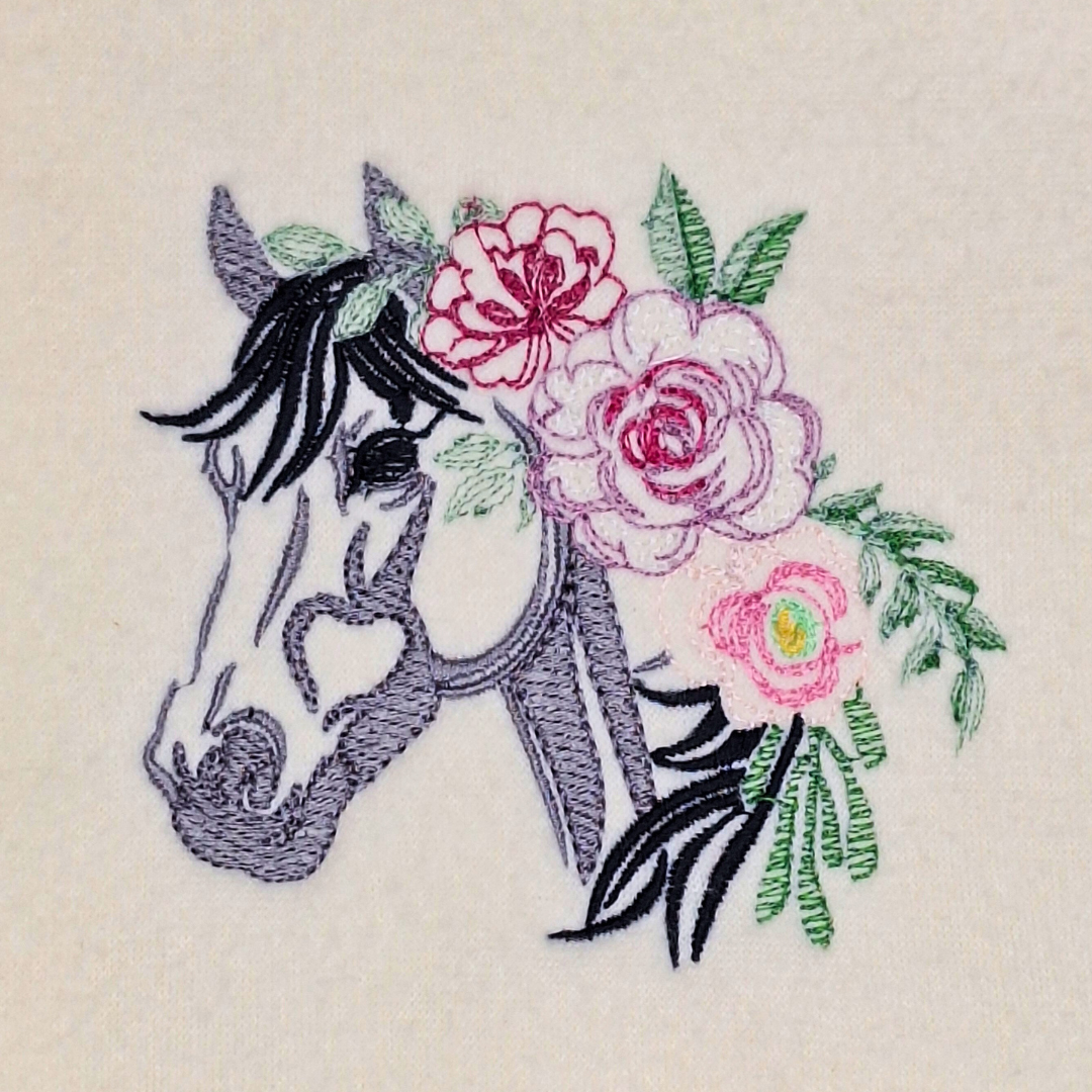 This is an image of a machine embroidery design by Stitches & Strokes, featuring a horse with flowers in its hair. This horse machine embroidery design is a modern design including Fill, Satin, and Running Stitches.