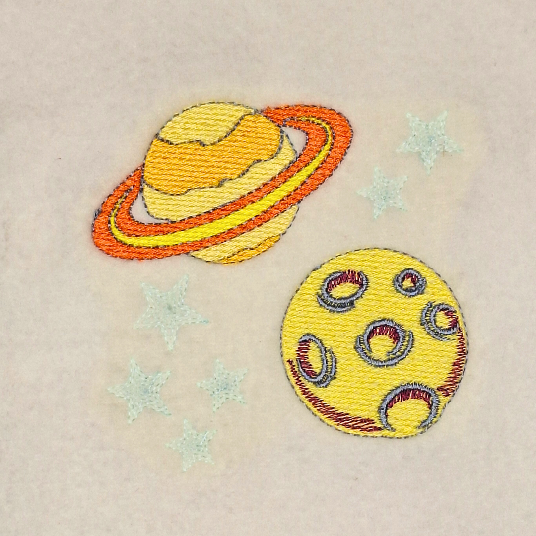 This is an image of a machine embroidery design featuring two brightly colored planet surrounded with stars.