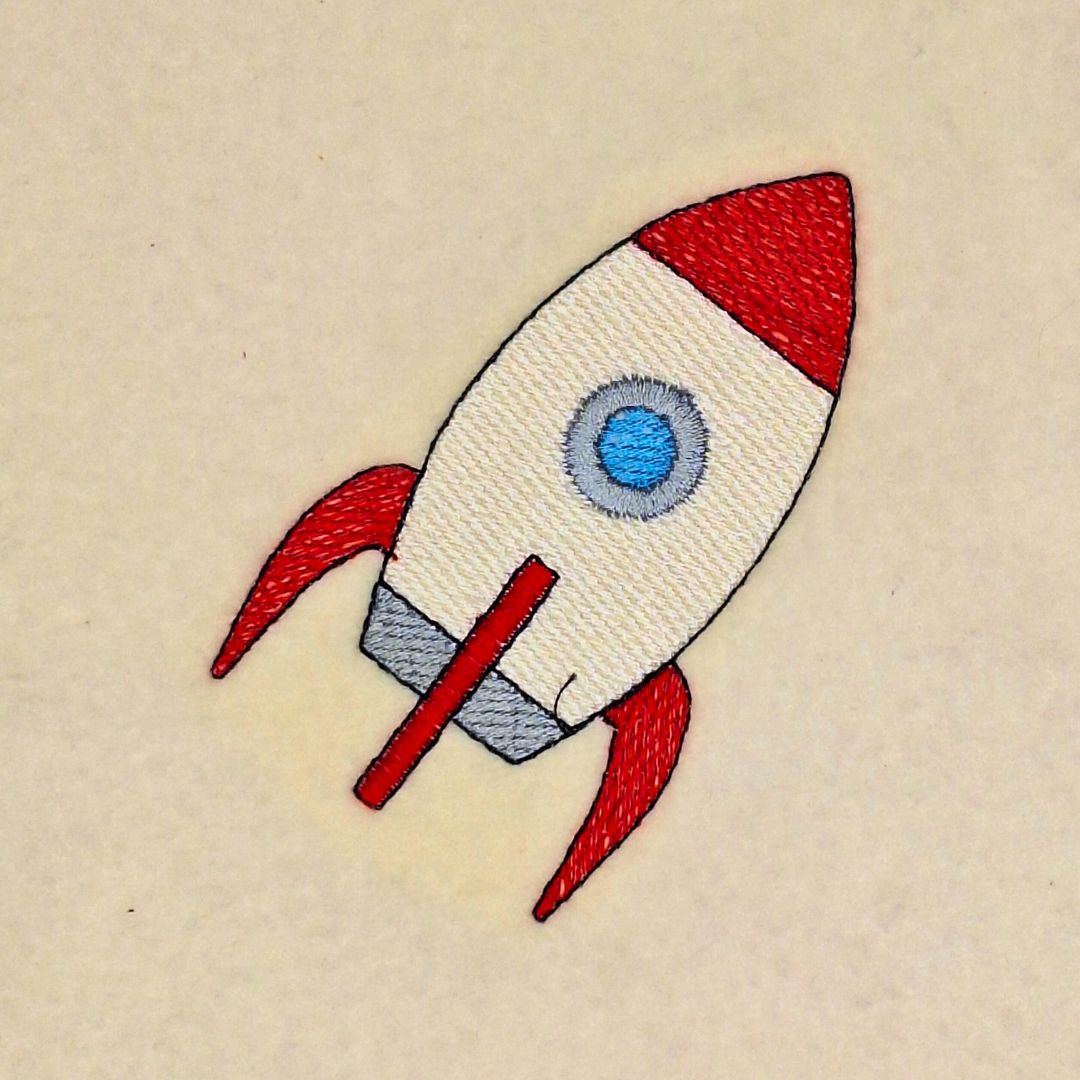 This is an image of a space ship machine embroidery design in grey and red. This spaceship is ideal for embroidery on baby onesies and t-shirts for toddlers.