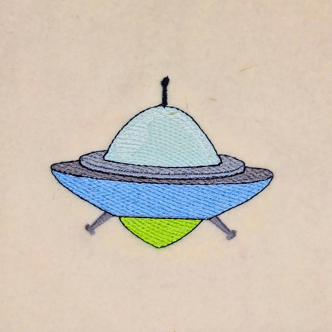 This is an image of a captivating Spaceship Machine Embroidery Design, perfect for adding a touch of cosmic adventure to your sewing projects.