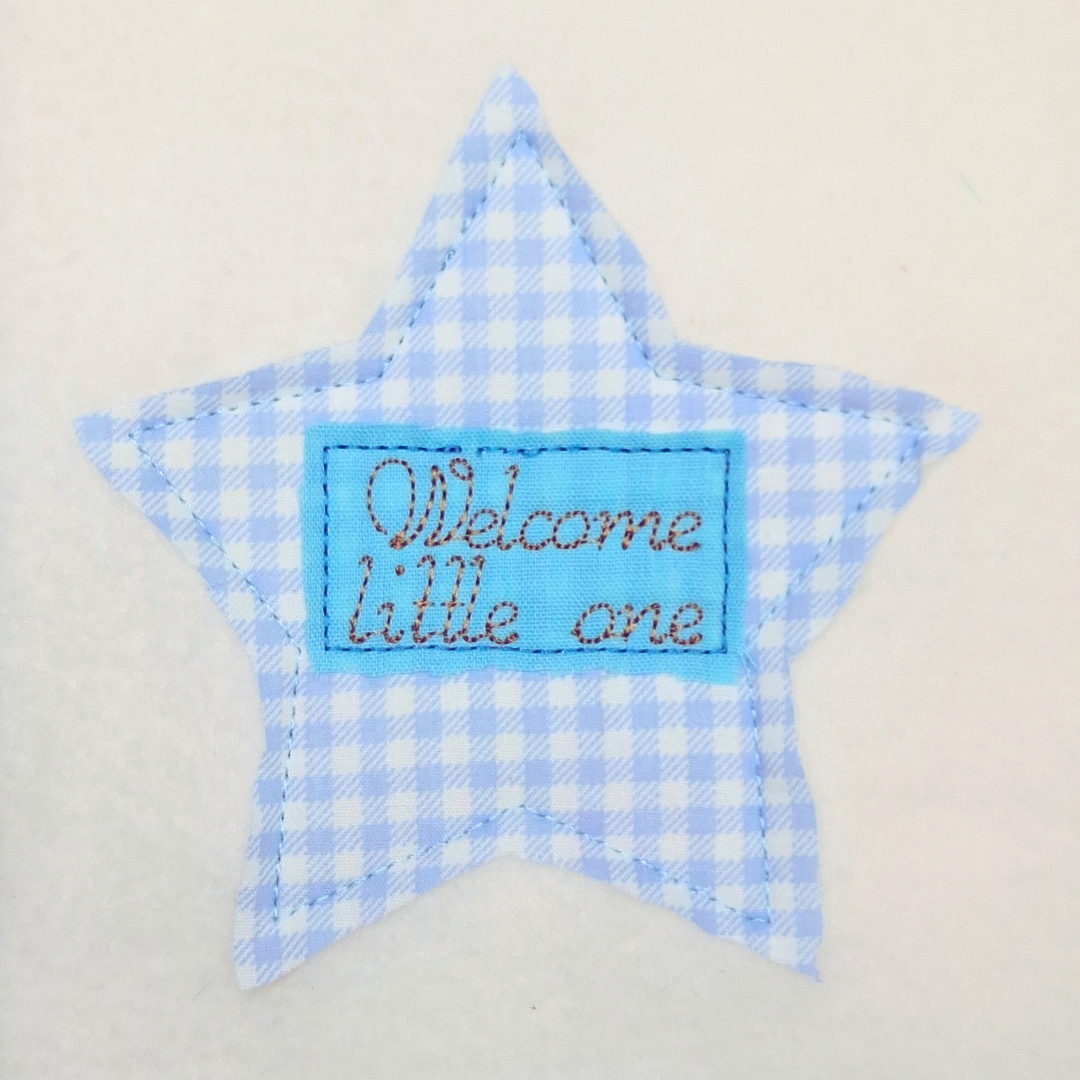 This is an image of an Applique Machine embroidery design featuring a Star with rectangle border and "Welcome little one" Quote. This Applique star machine embroidery star design is perfect for adding detail to baby shower gifts like baby blankets, onesies, burp cloths, and more.