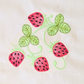 This is an image of a machine embroidery design featuring a strawberry plant with green vines and leaves. This strawberry machine embroidery design is perfect for embroidery on items and accessories for the kitchen like aprons, oven mittens, and tablecloths. This strawberry design can also be embroidered on dresses for girls.