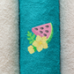 This is an image of a machine embroidery design from Stitches & Strokes, featuring a watermelon with a watermelon bloom. This watermelon machine embroidery design is perfect for embroidery on kitchen towels, beach towels, and tote bags.