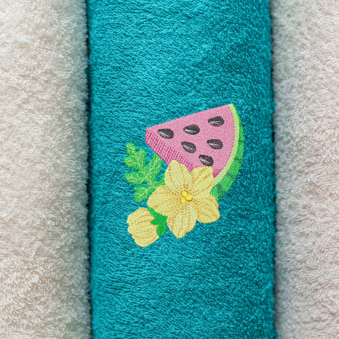 This is an image of a machine embroidery design from Stitches & Strokes, featuring a watermelon with a watermelon bloom. This watermelon machine embroidery design is perfect for embroidery on kitchen towels, beach towels, and tote bags.