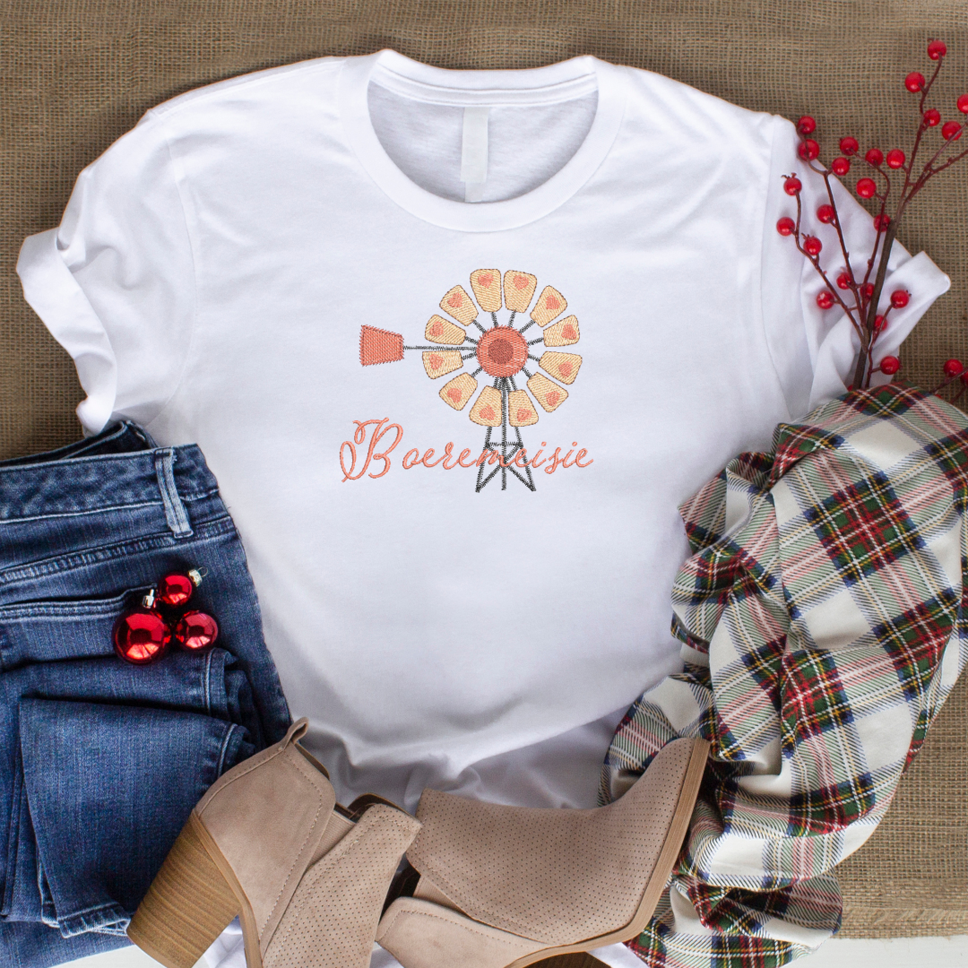 This is an image of a machine embroidery design by Stitches & Strokes, featuring a Windmill with hearts, and an Afrikaans "Boeremeisie" Quote. This Windmill with Boeremeisie Afrikaans Quote Machine Embroidery Design is perfect for embroidery on t-shirts for women's and girl's t-shirts.