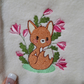 This is a machine embroidery design featuring a cute baby fox, surrounded by delicate magnolia flowers. This adorable baby woodland fox machine embroidery design is available in 4x4, and 5x7 hoop sizes.