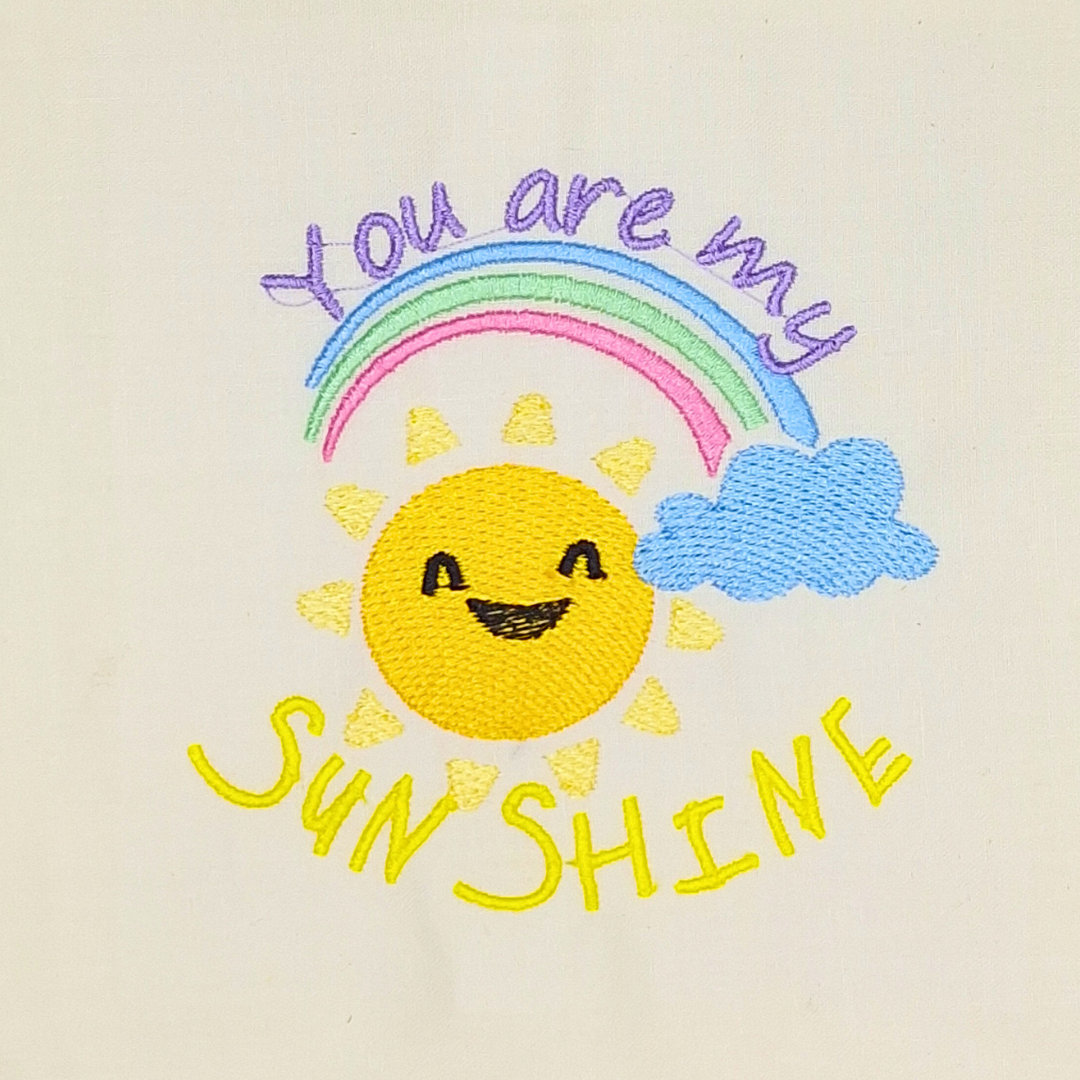 This is an image of a machine embroidery design featuring a cute cartoon sun, rainbow, and cloud with the Quote "You are my Sunshine.