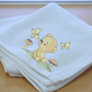 This is an image of a machine embroidery design featuring a baby bear sitting in the field with mushrooms and watching butterflies fluttering by. This baby bear and butterfly machine embroidery design is perfect for embroidery on baby items and gifts like baby blankets, bibs, burp cloths, and more.