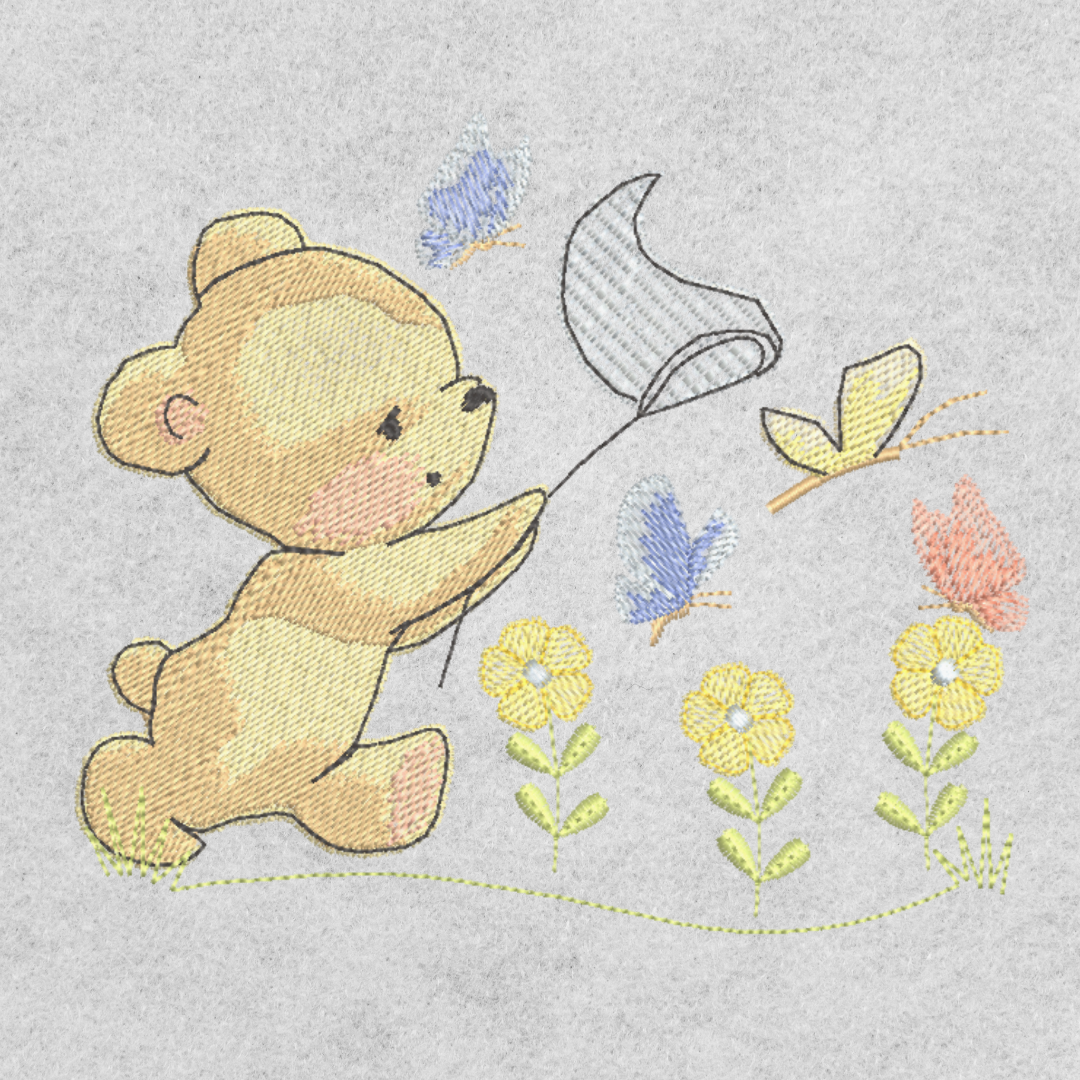 This is an image of a machine embroidery design featuring a baby bear chasing butterflies with a net in a field of adorable flowers. This baby bear machine embroidery design is perfect for embroidery on baby items and gifts like blankets, towels, burp cloths, and more