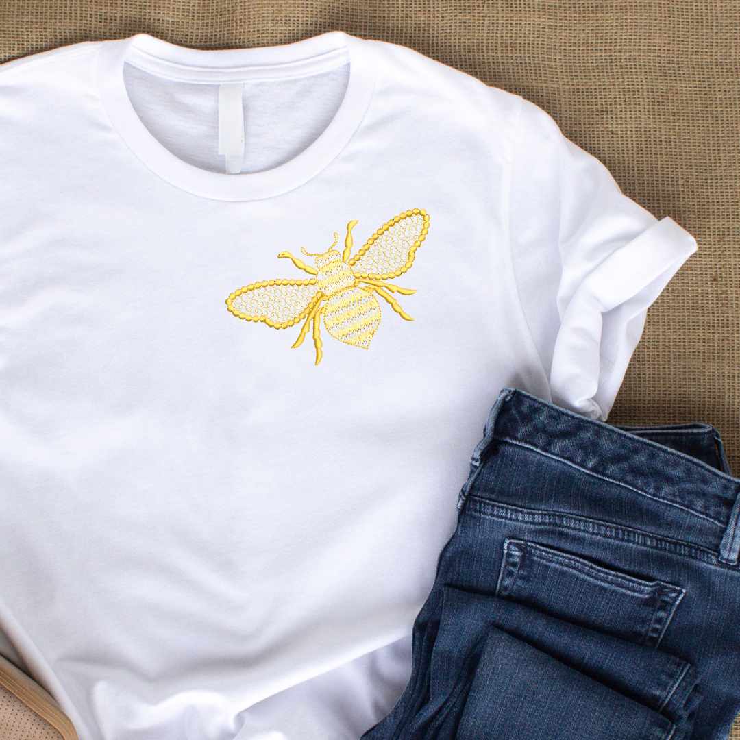 This is an image of a machine embroidery design featuring a golden bee with filigree detail in the wings and body. This design is perfect for embroidery on t-shirts and denim.